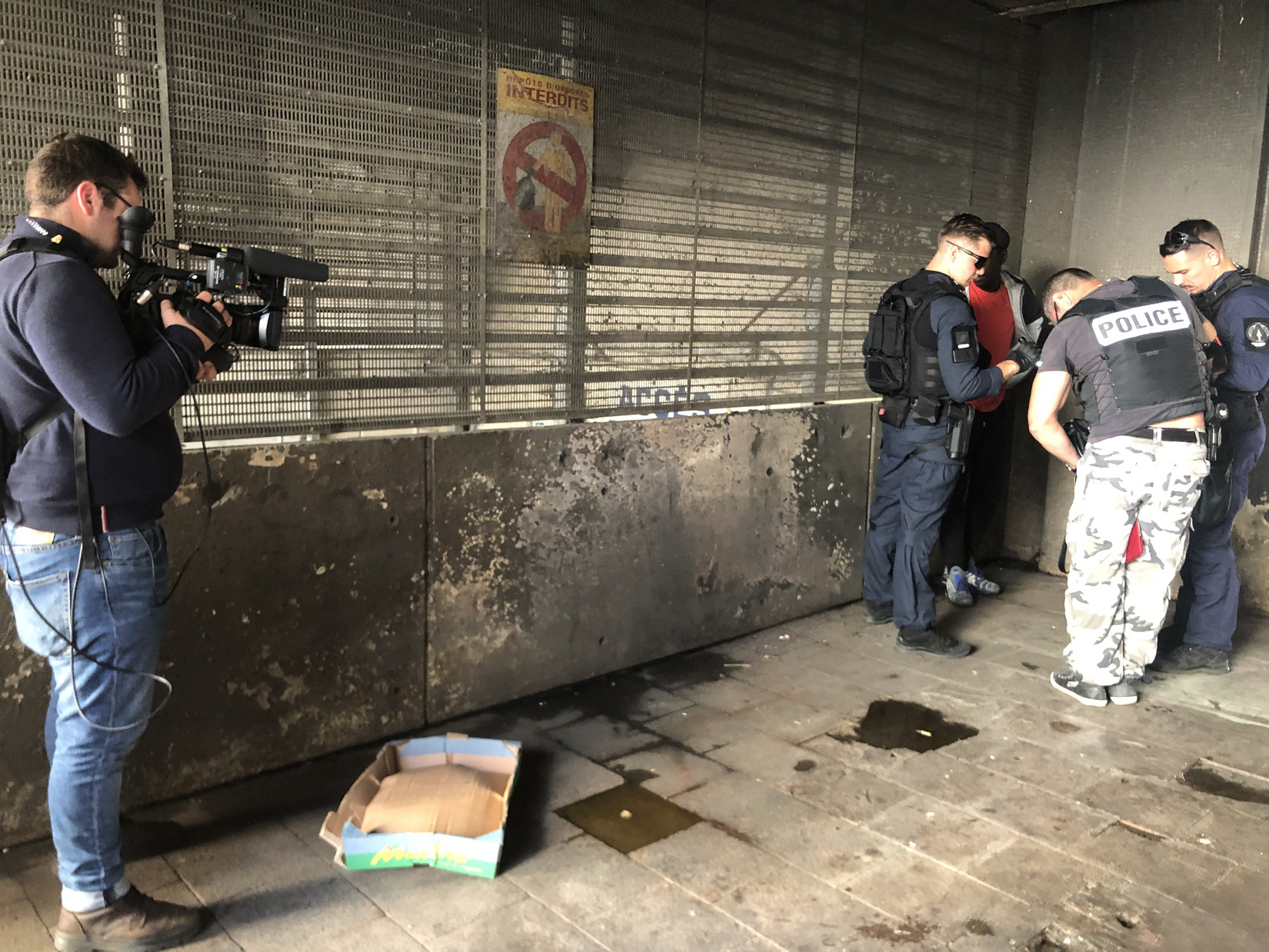 Un contrôle de police sous les caméras de journalistes sous les porches de Galerie Wagner. Crédit photo : GG